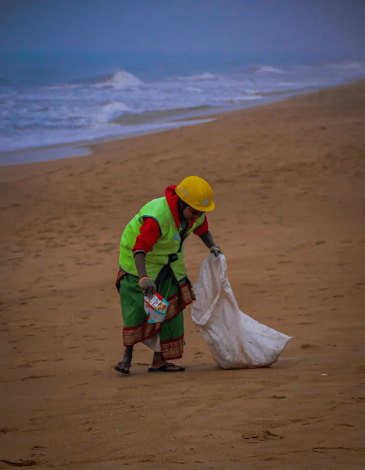 Volunteer collecting waste on a beach