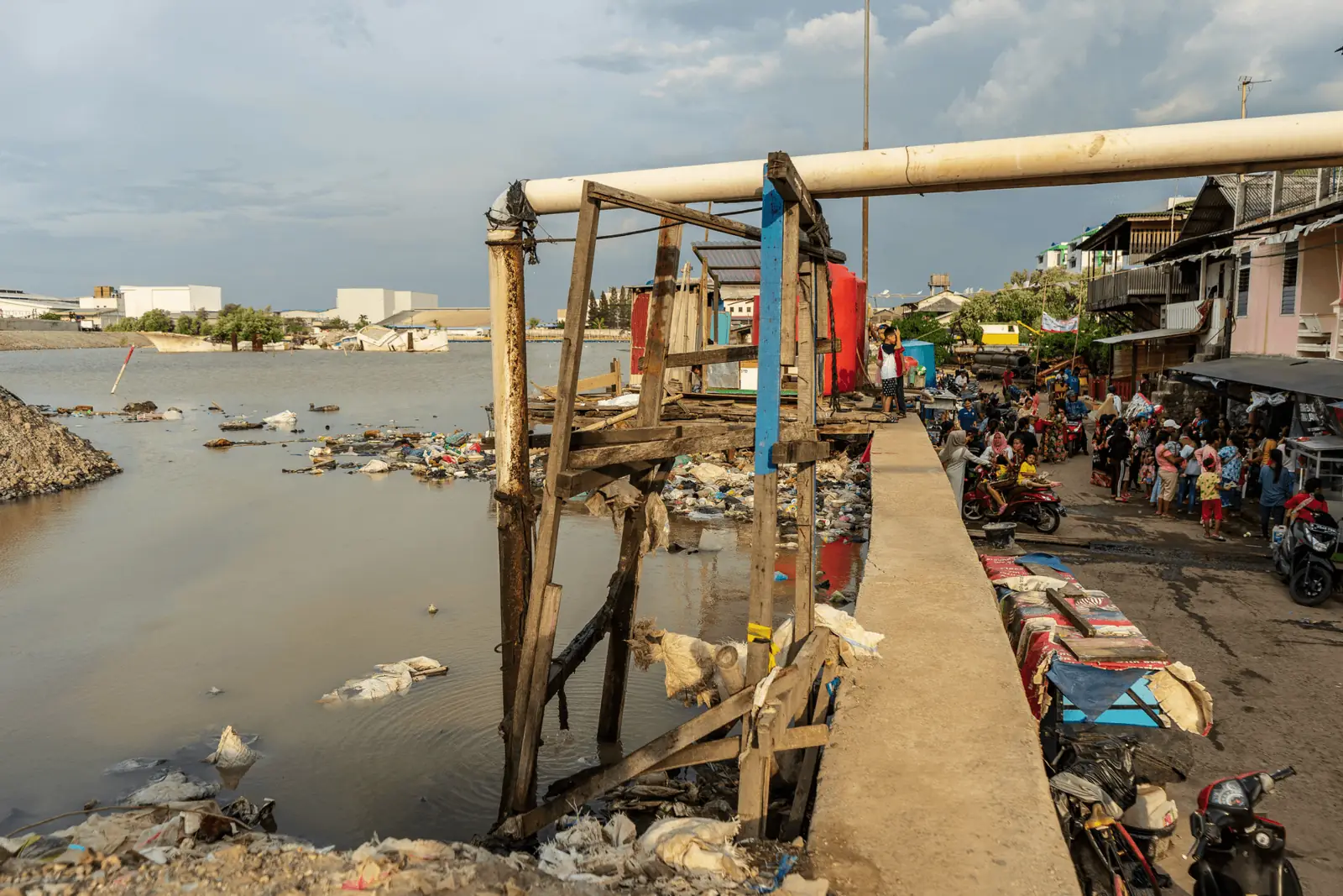 Un barrio abarrotado junto a un canal del puerto lleno de basura