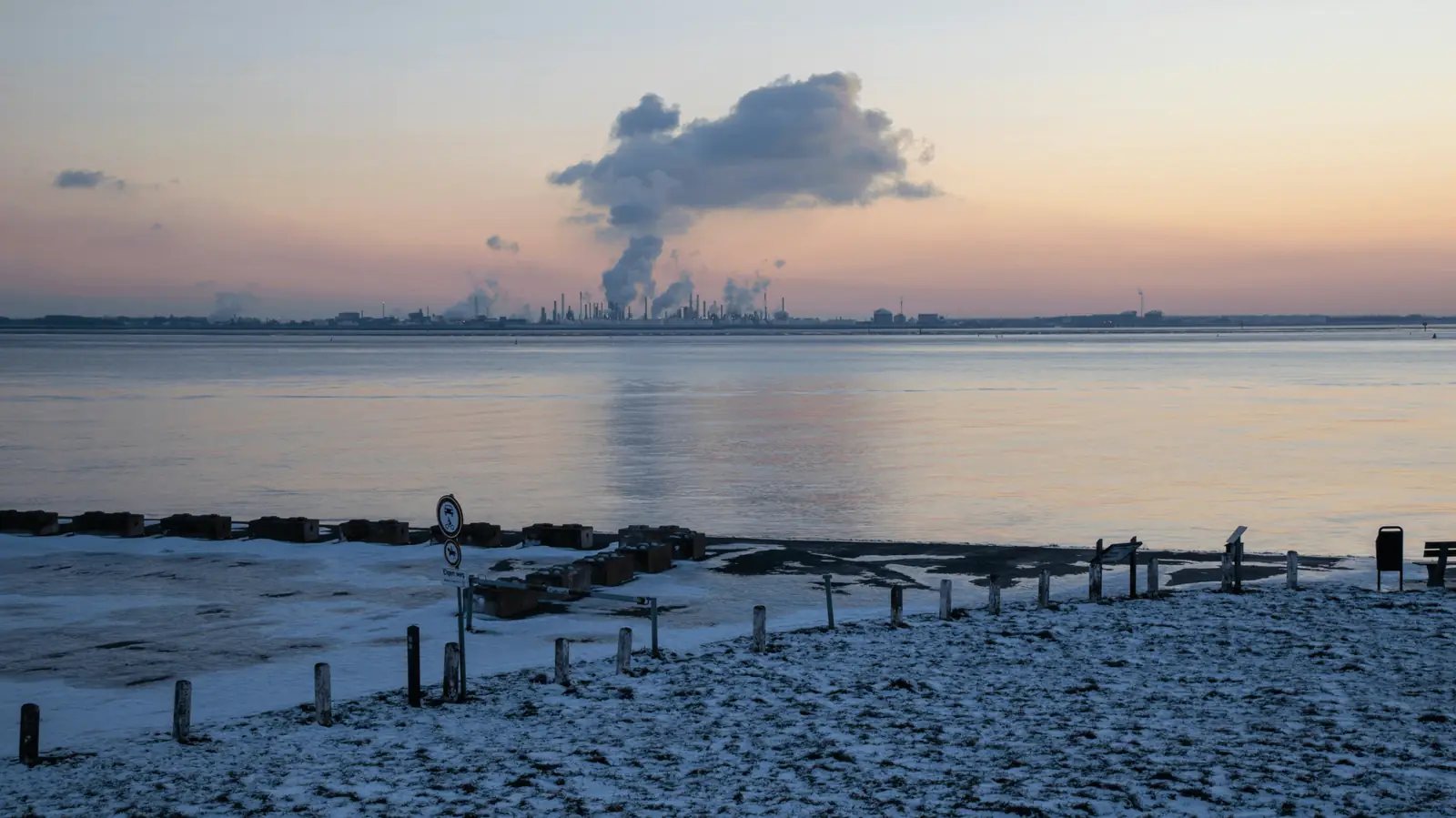 Industrial emissions on the horizon over a beach