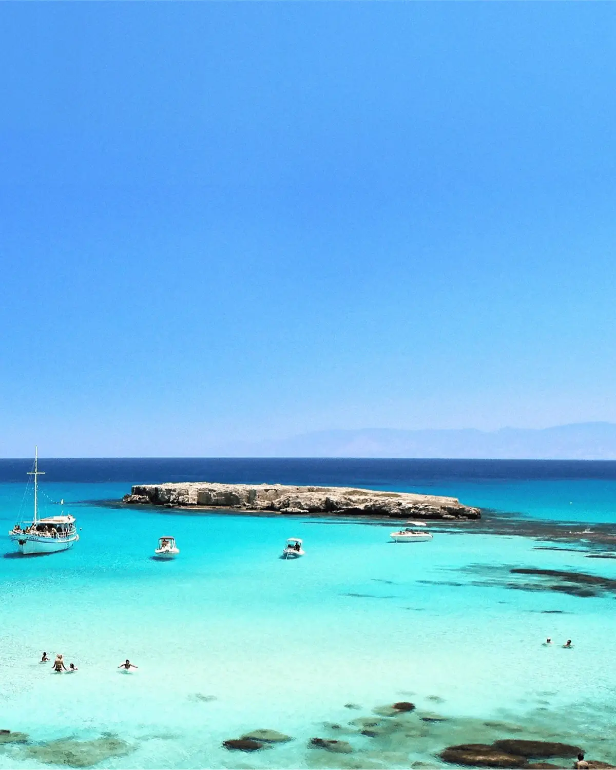 Boats anchored in a clear Mediterranean lagoon