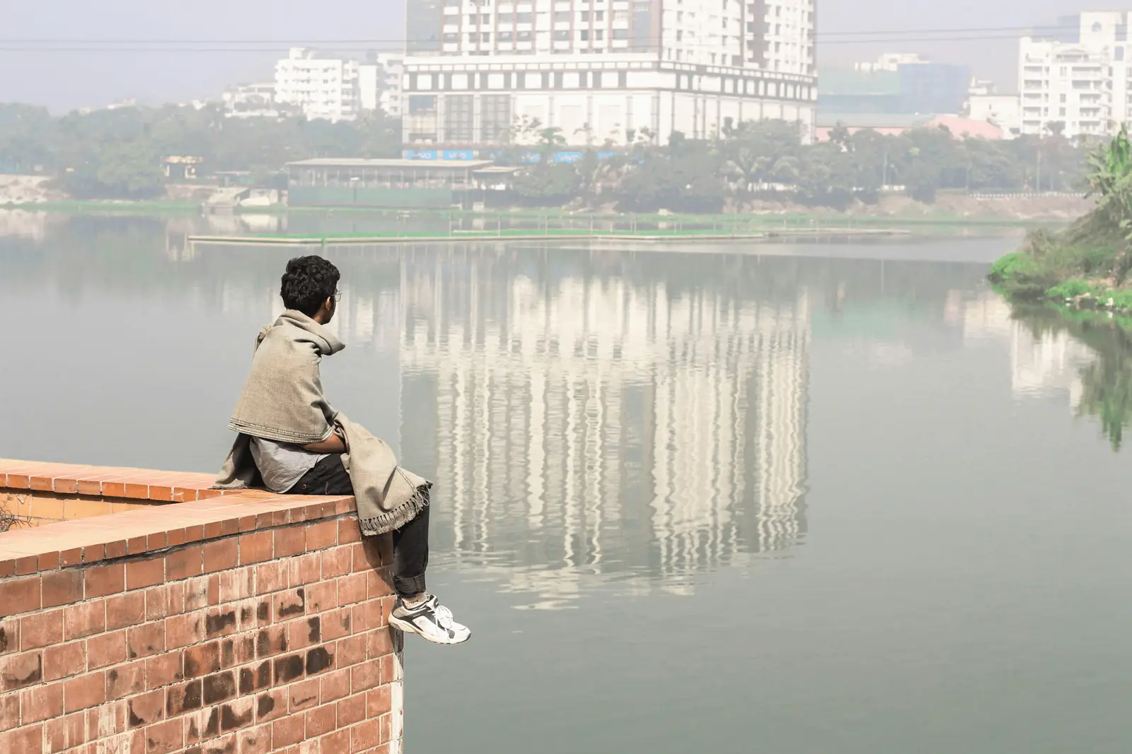 A person observing a polluted urban waterfront