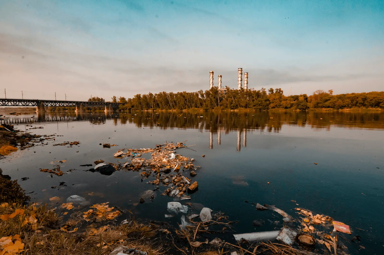 Industrial waste along a shoreline at dusk